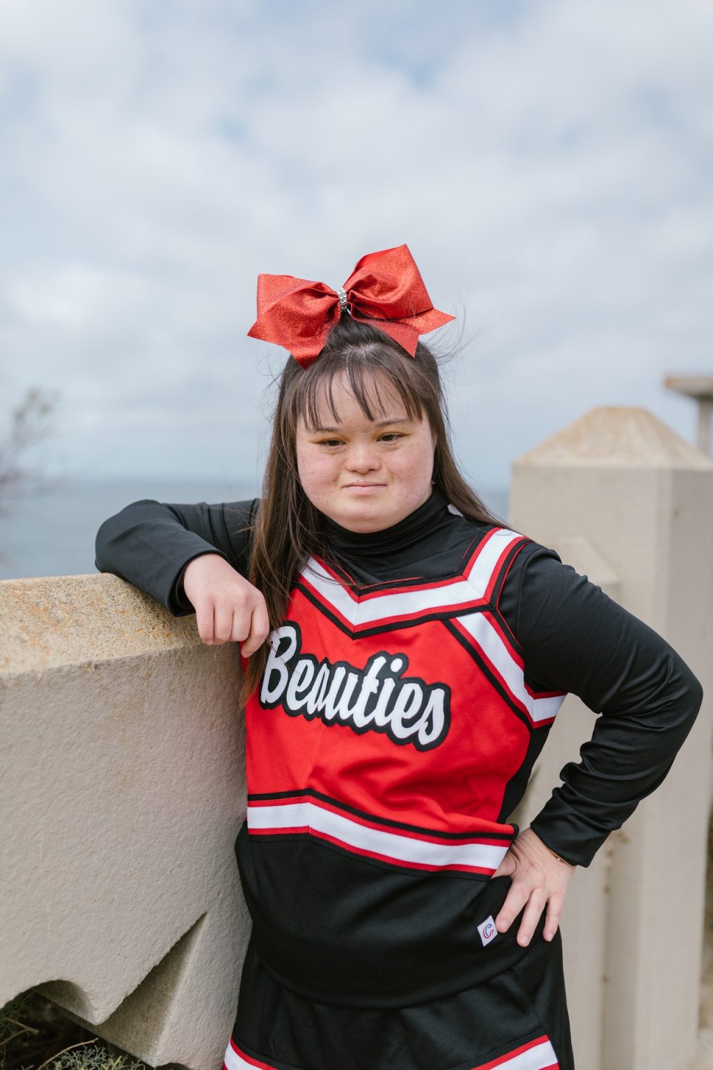 Girl with down syndrome dressed as a cheerleader and having fun with her NDIS service provider