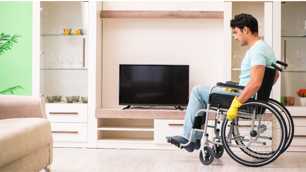 man on wheelchair cleaning his house